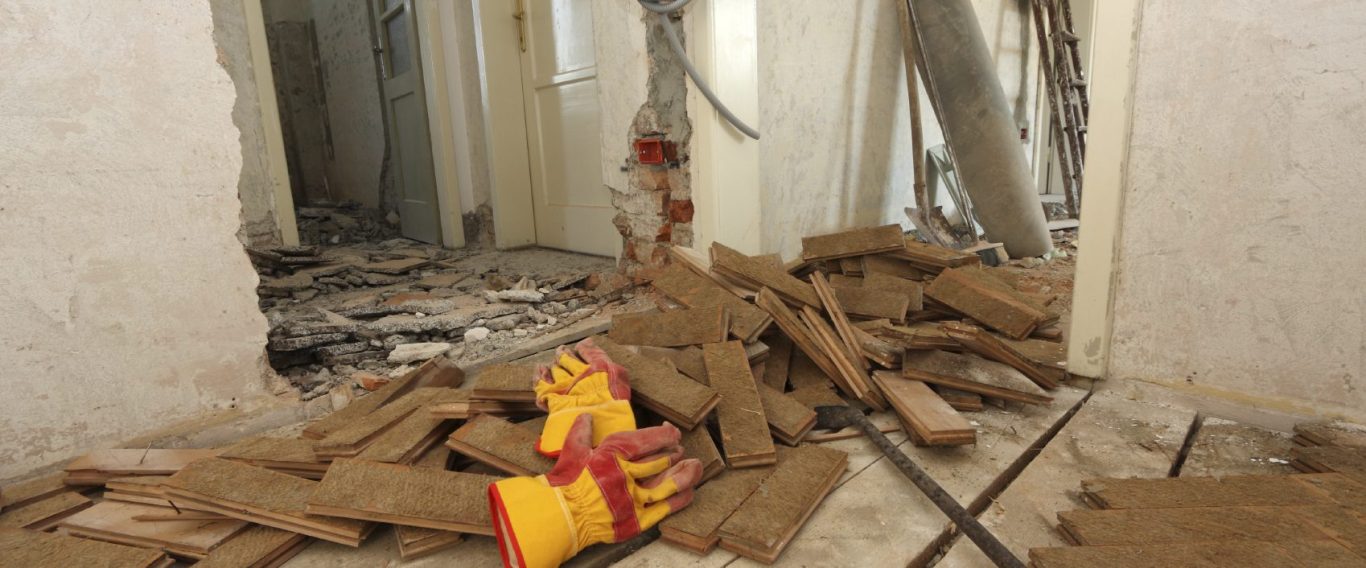 Baustellen Reinigung Baustelle mit Schutt, Handschuh und Mauerrückständen in einem unvollendeten Raum.